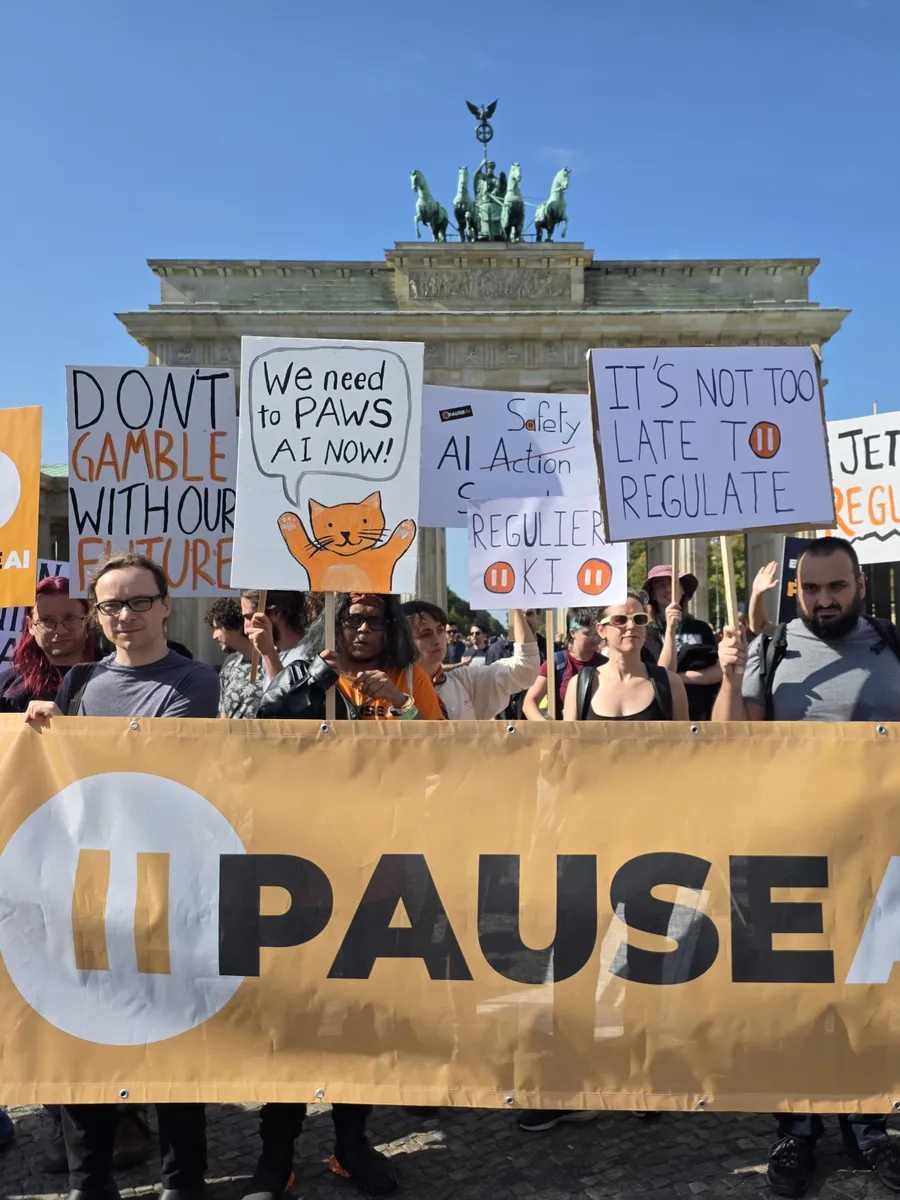 PauseAI-Demonstration mit Banner und Schildern vor dem Brandenburger Tor in Berlin